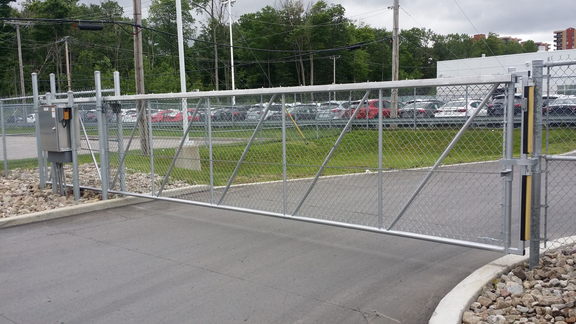 Une clôture grillagée bloque l'entrée d'un parking.