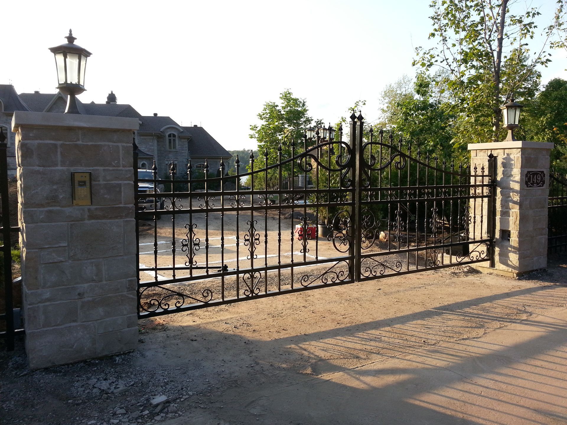 Un portail en fer forgé est entouré de piliers en pierre