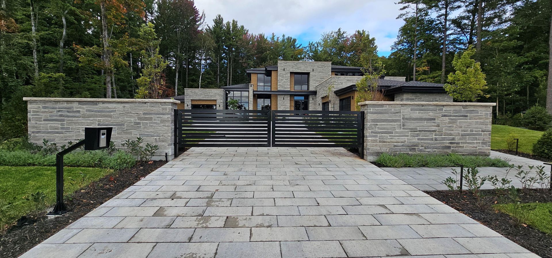 Une allée menant à une grande maison avec un portail.