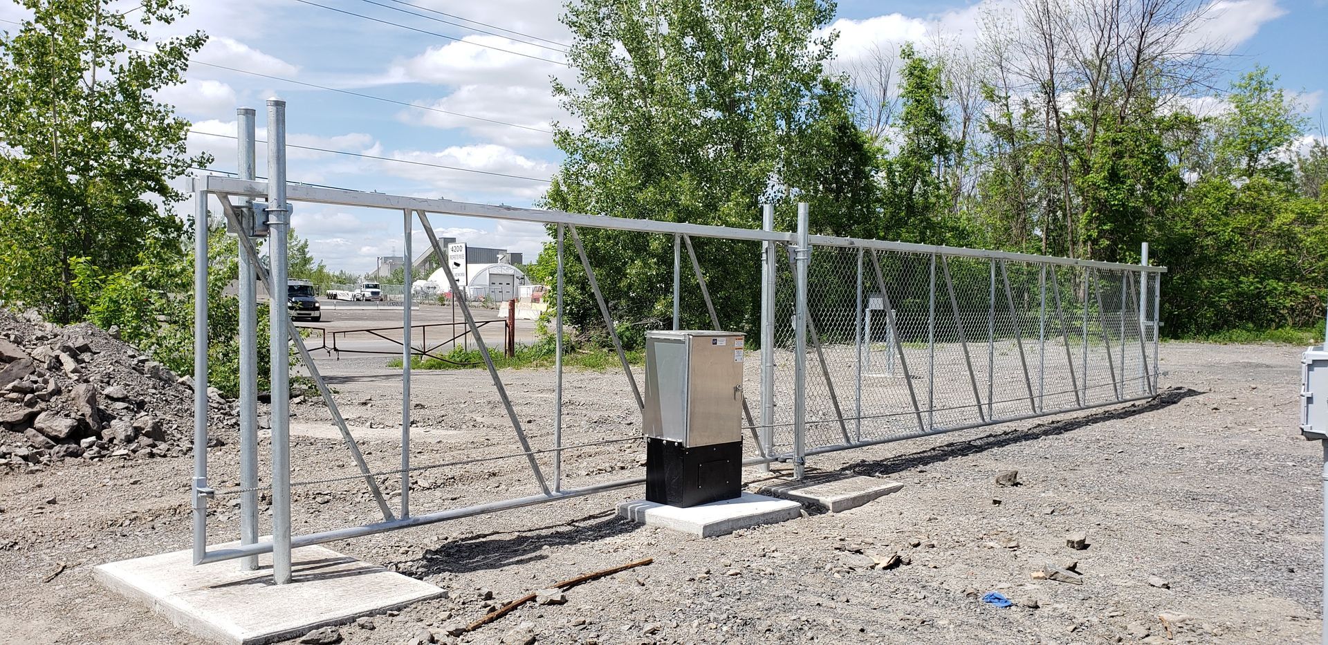 Une porte en métal est posée sur un chemin de gravier.