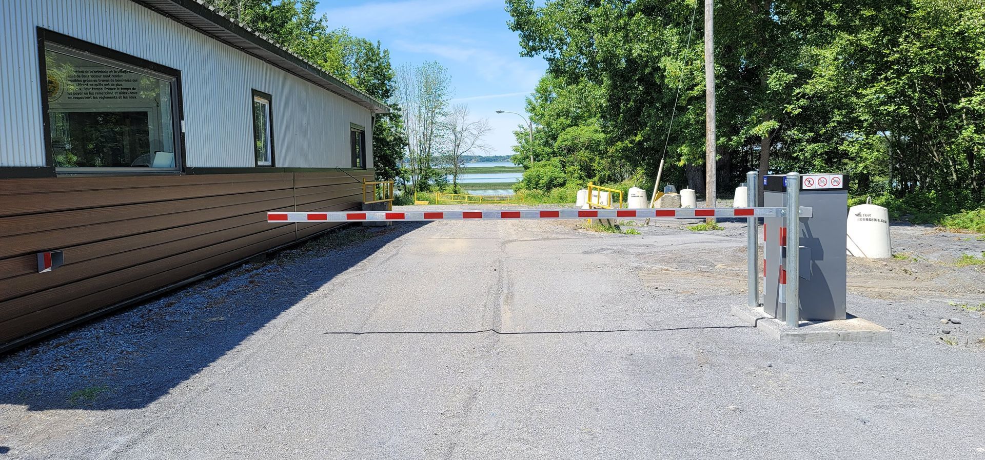 Il y a une barrière sur le côté de la route devant une maison.