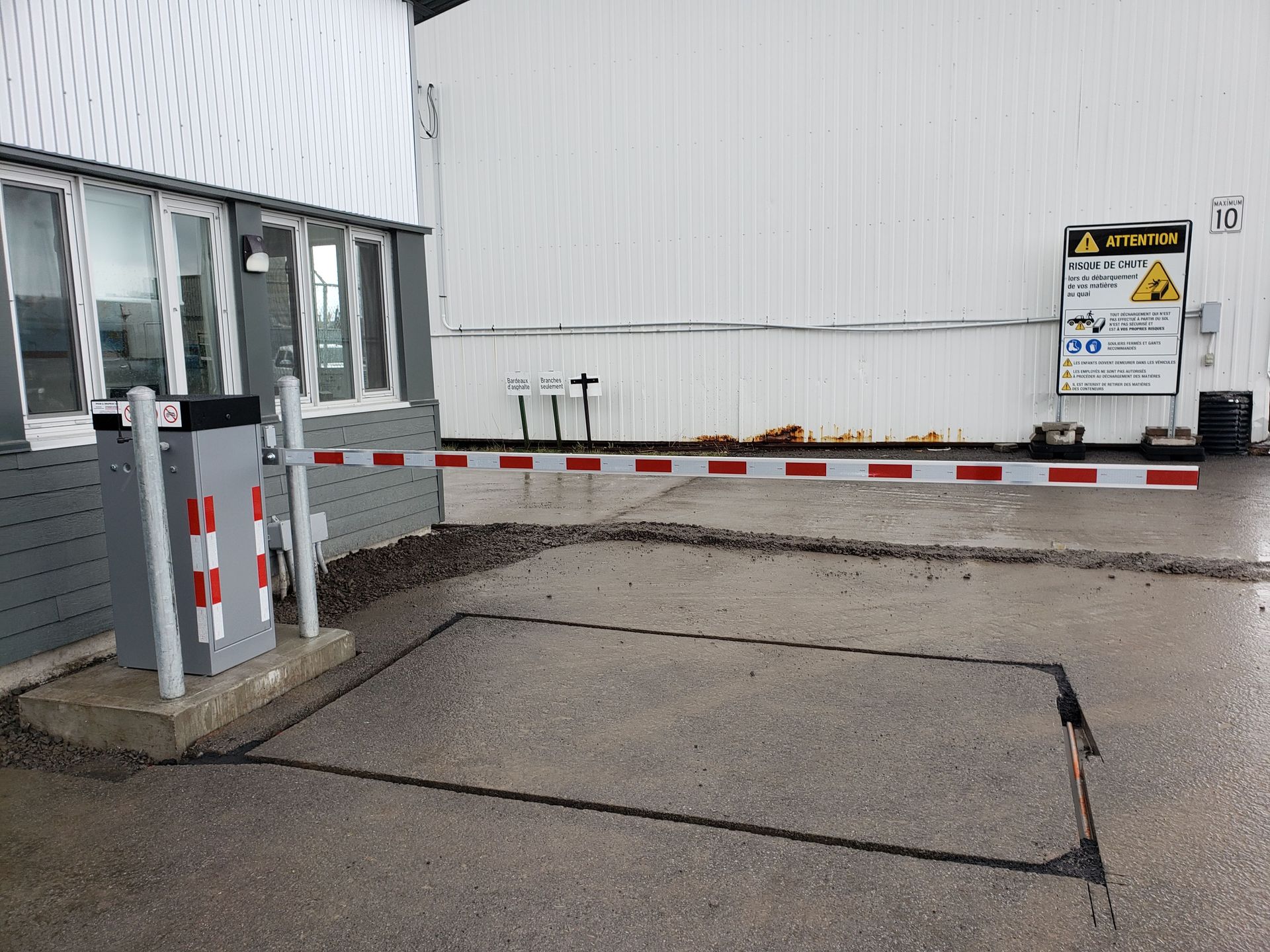 Un bâtiment avec une barrière et un panneau sur le côté.