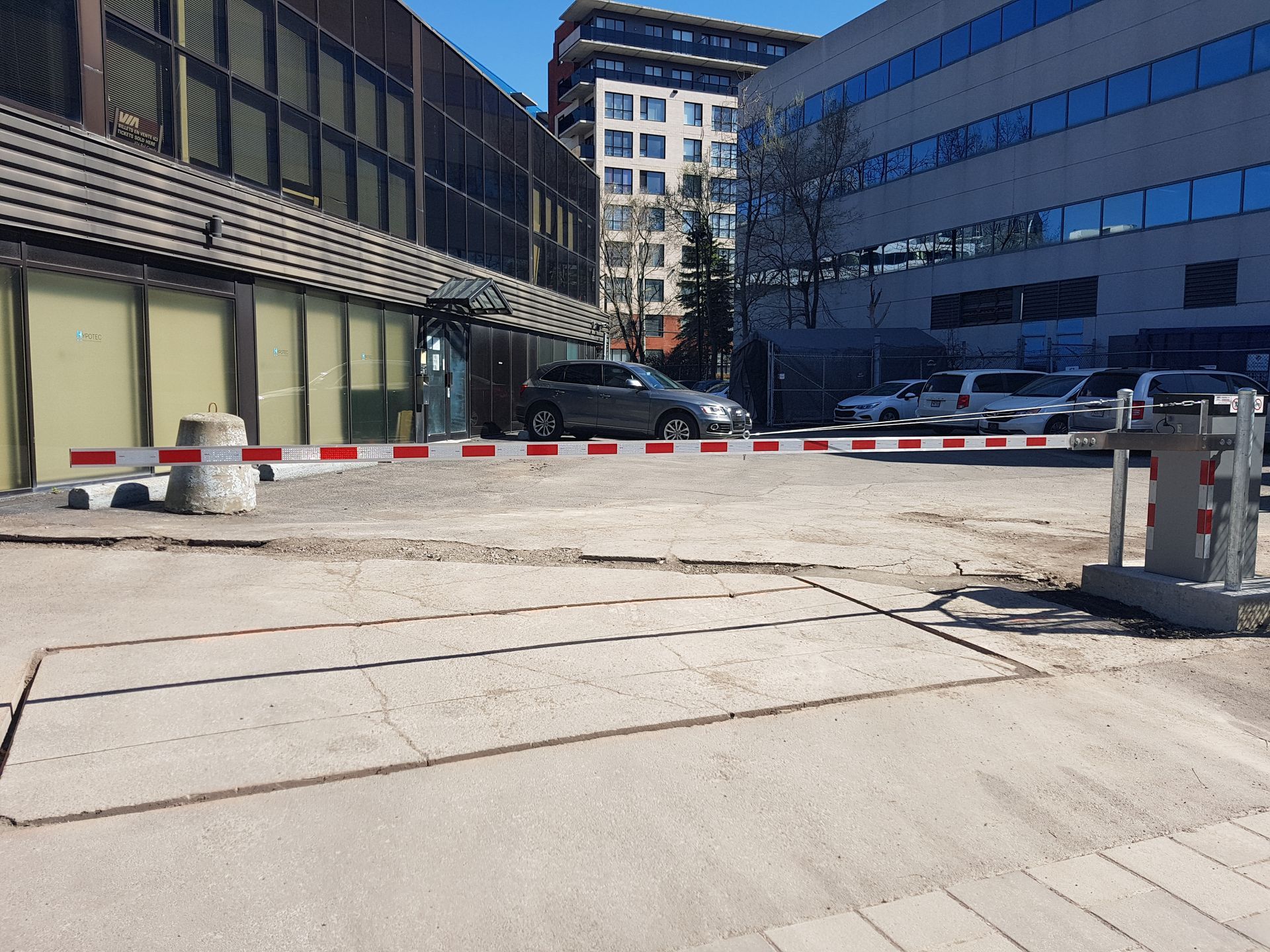 Un parking avec une barrière et un bâtiment en arrière-plan