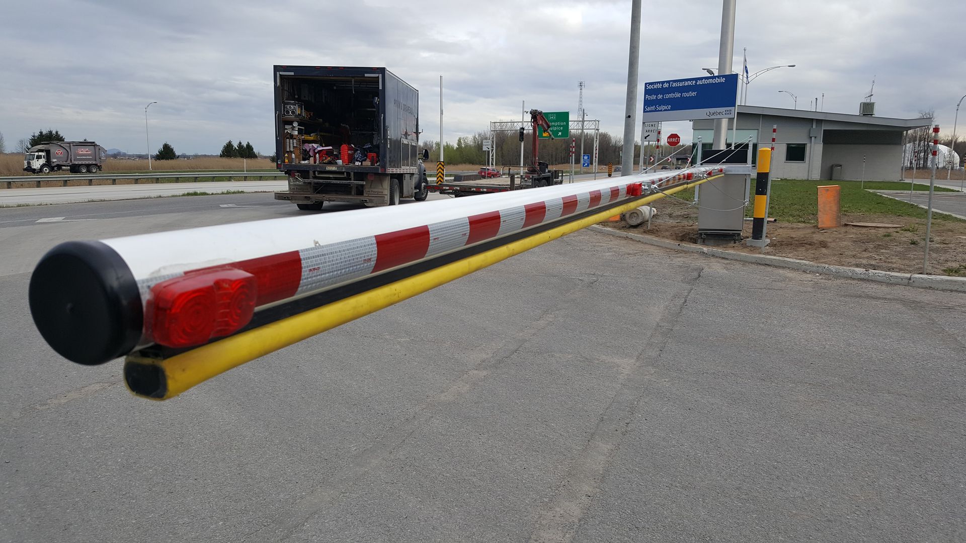 Un camion est garé derrière une barrière sur le bord de la route.