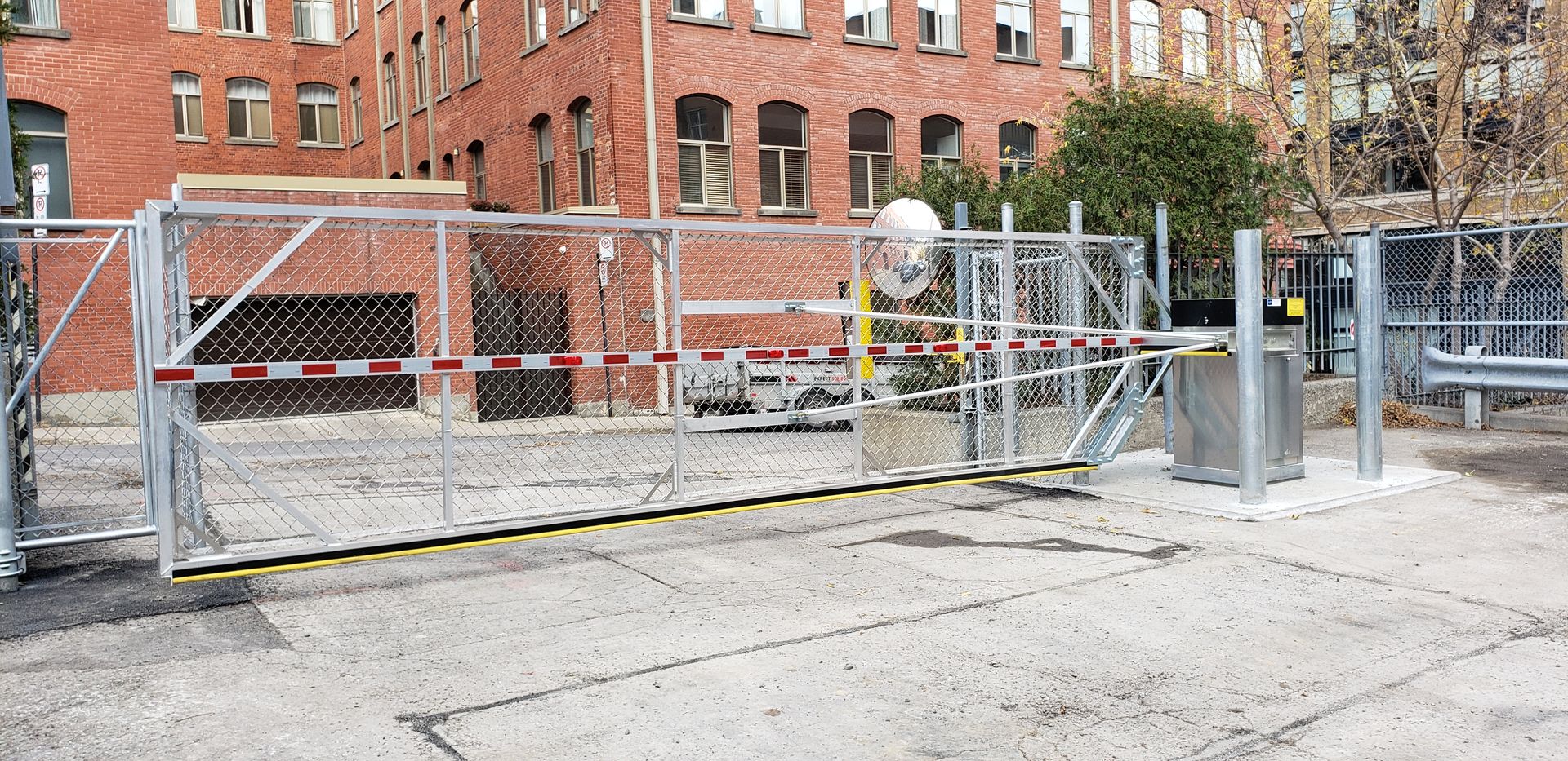 Une grande porte en métal se trouve devant un bâtiment en briques.