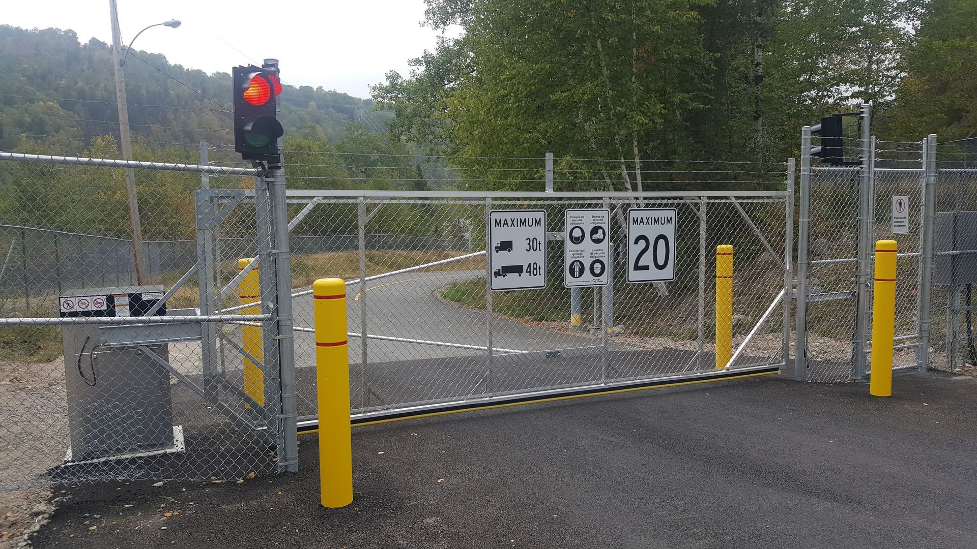 Une clôture avec un feu rouge et un panneau indiquant 20