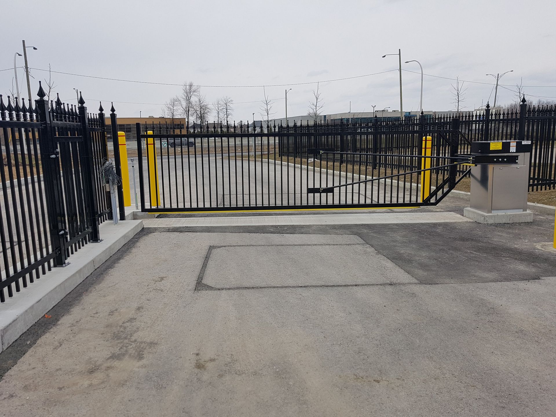 Une clôture noire avec un poteau jaune sur le côté