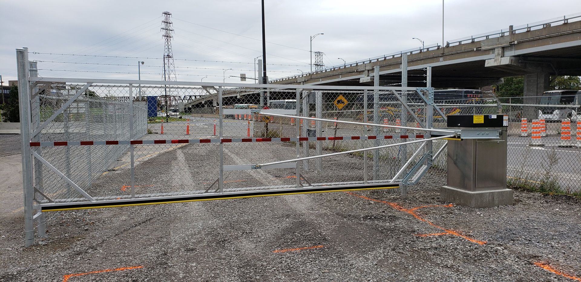 Une porte en métal se trouve au milieu d'un chemin de gravier.