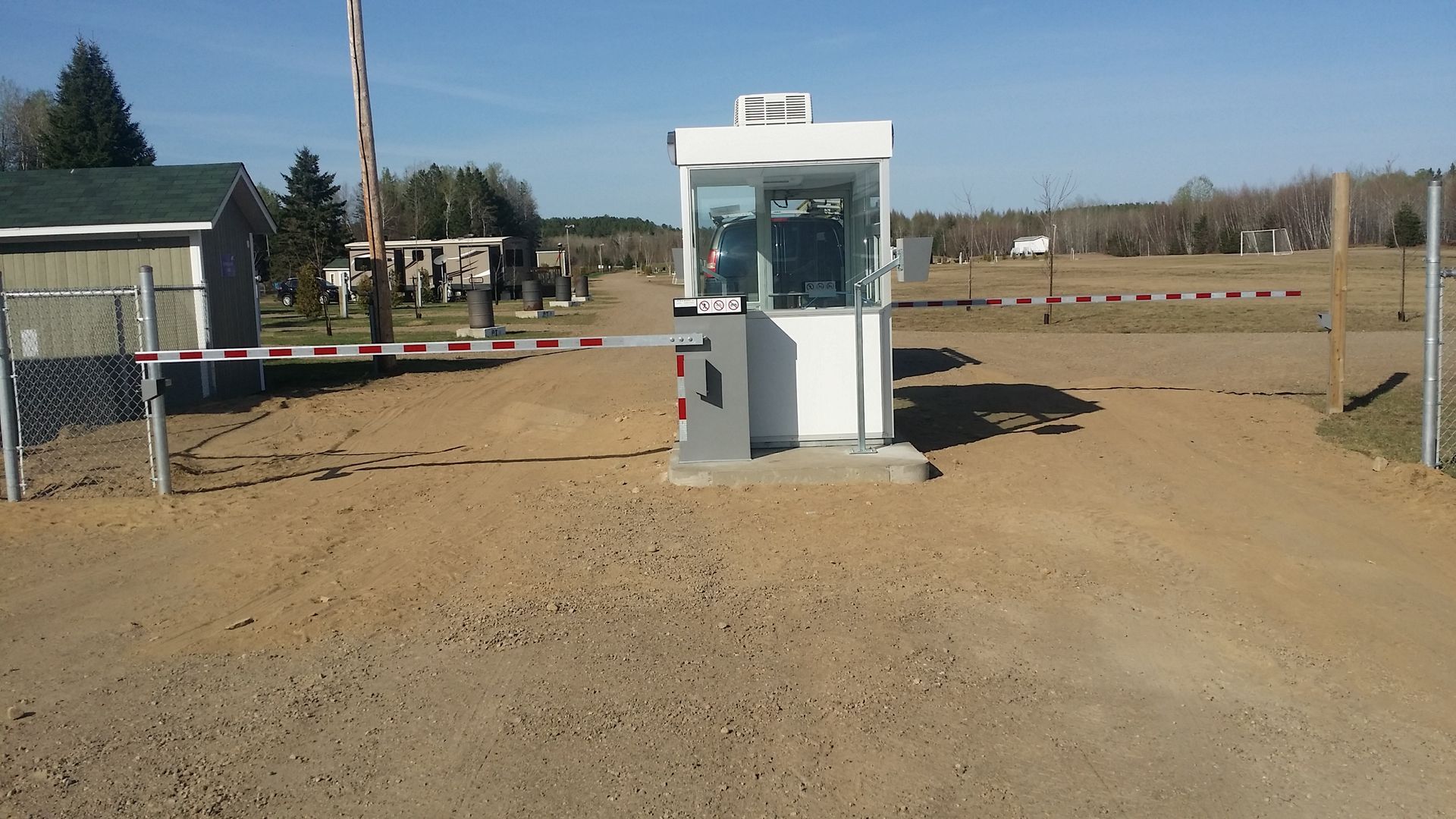Une porte avec une barrière au milieu d'un chemin de terre