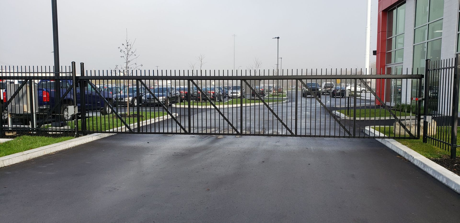 Une grande porte métallique bloque l'entrée d'un parking.