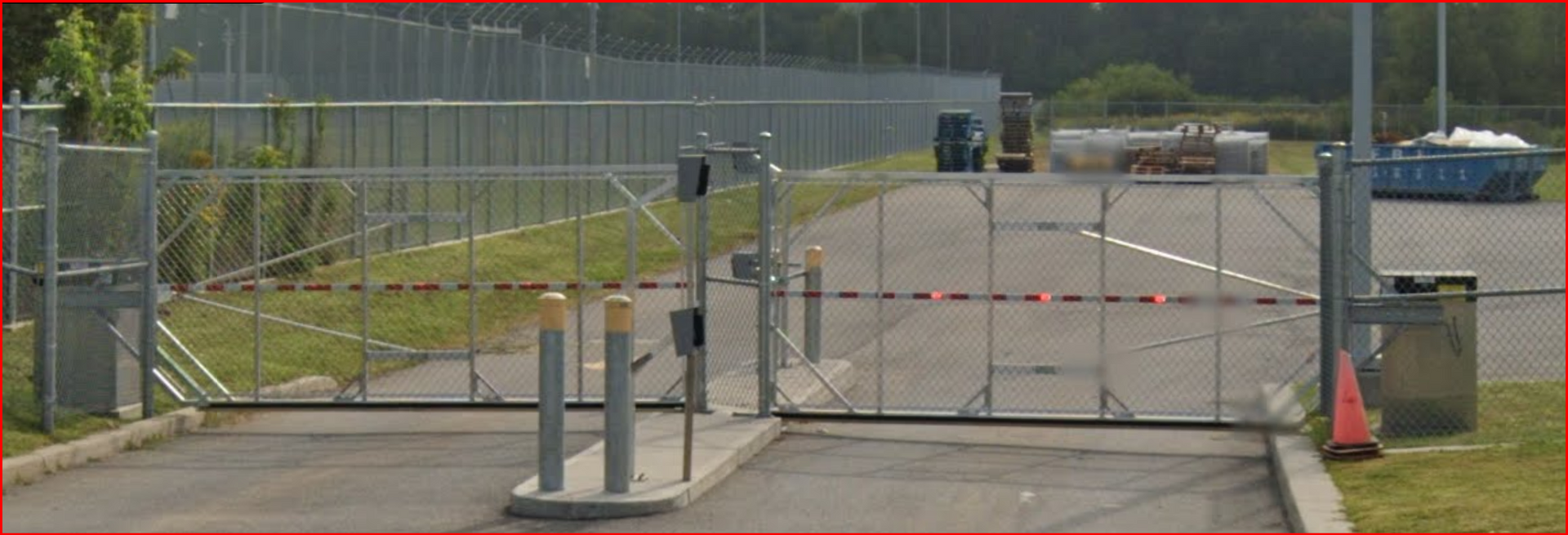 Une clôture avec un portail bloquant l'entrée d'un parking.