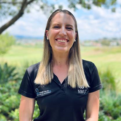 Woman smiling outdoors wearing a black NWU polo shirt with a golf course in the background.