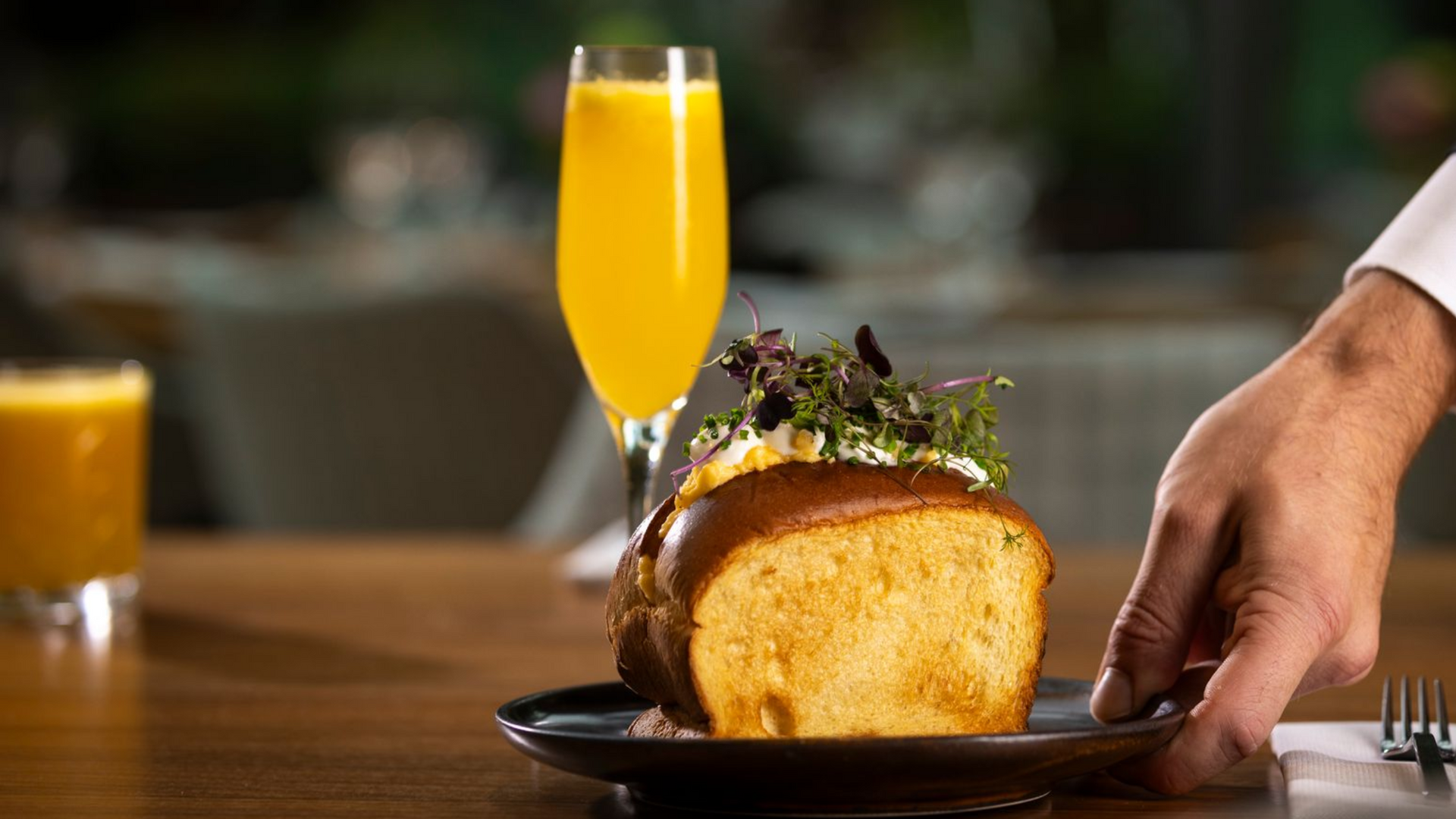 Teal sofa with two abstract paintings above, flanked by lamps, in a modern living room.