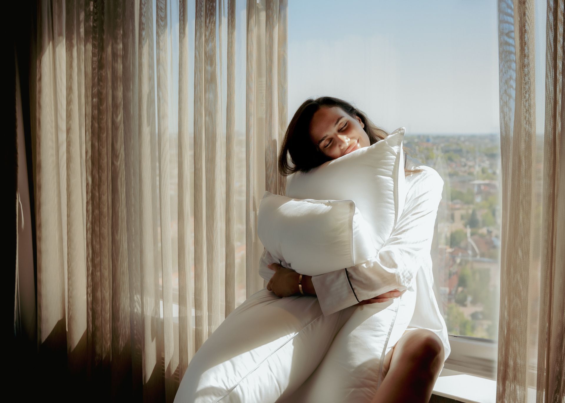 Woman in pink kimono with blue obi, hands clasped over stomach.