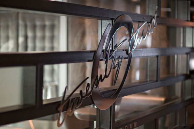 Metal sign for “Twenty” restaurant on a glass door.