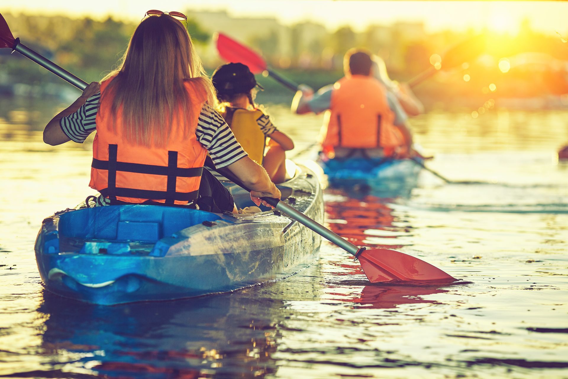 A group of people are paddling kayaks on a lake.