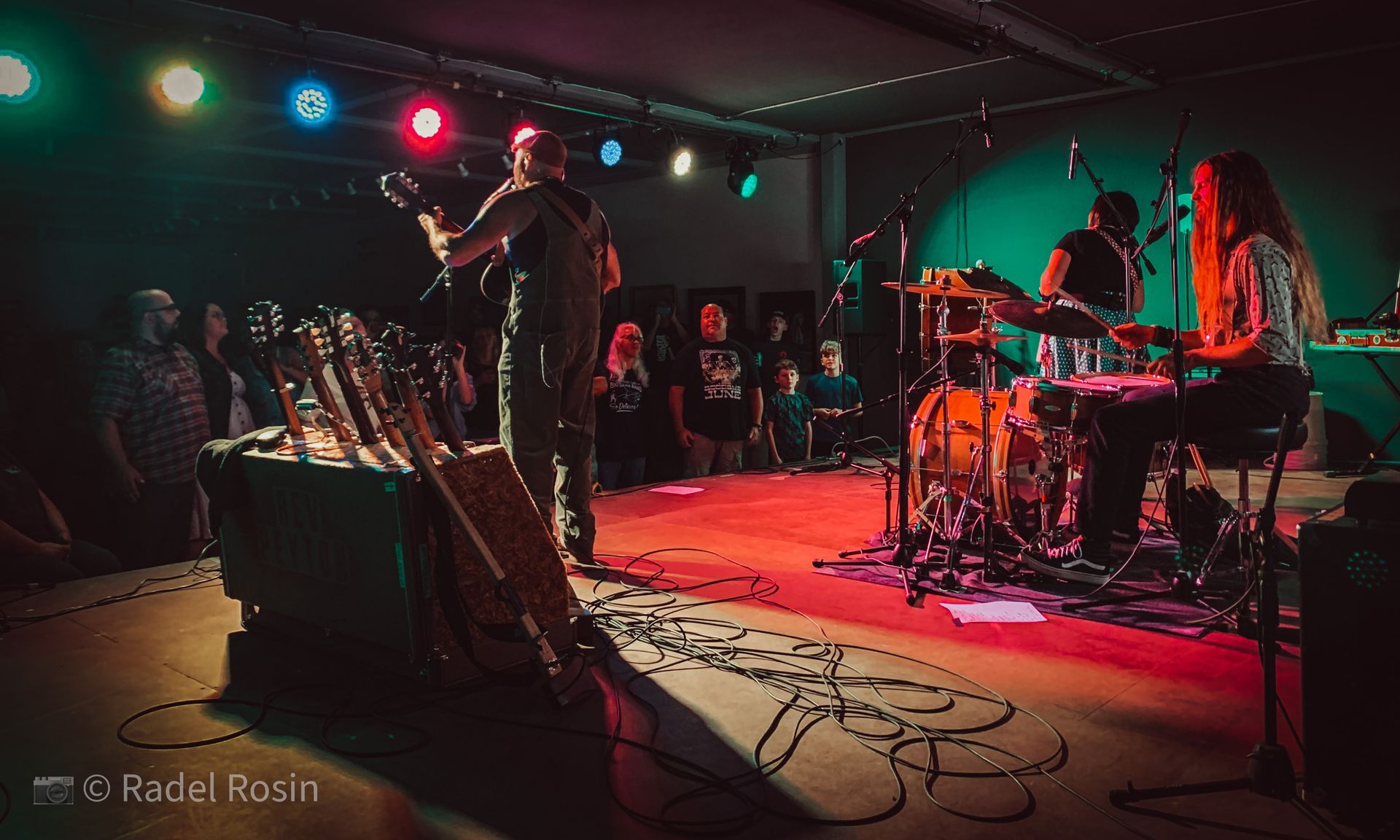 A group of people are playing instruments on a stage in front of a crowd.