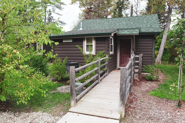 A small house with a wooden ramp leading to the door.