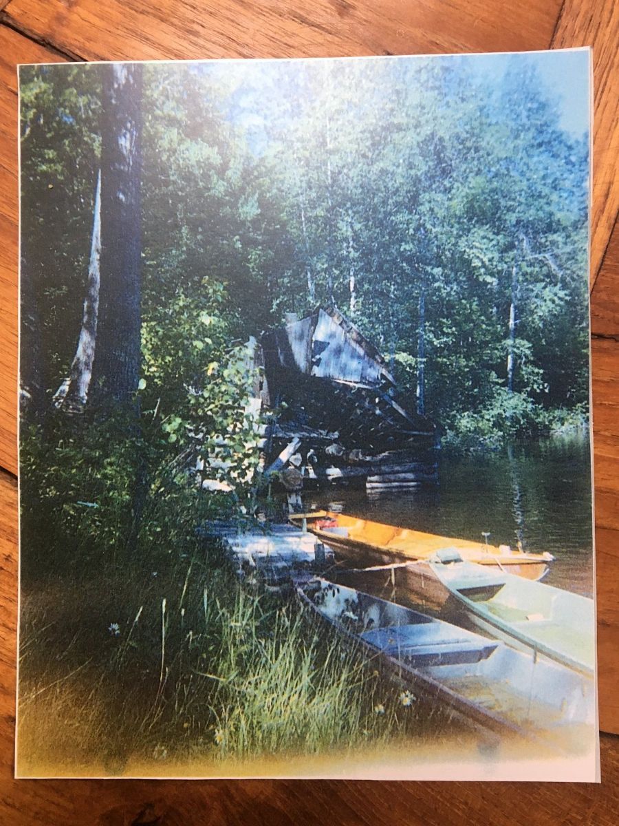 A picture of a boat on a dock in the woods.