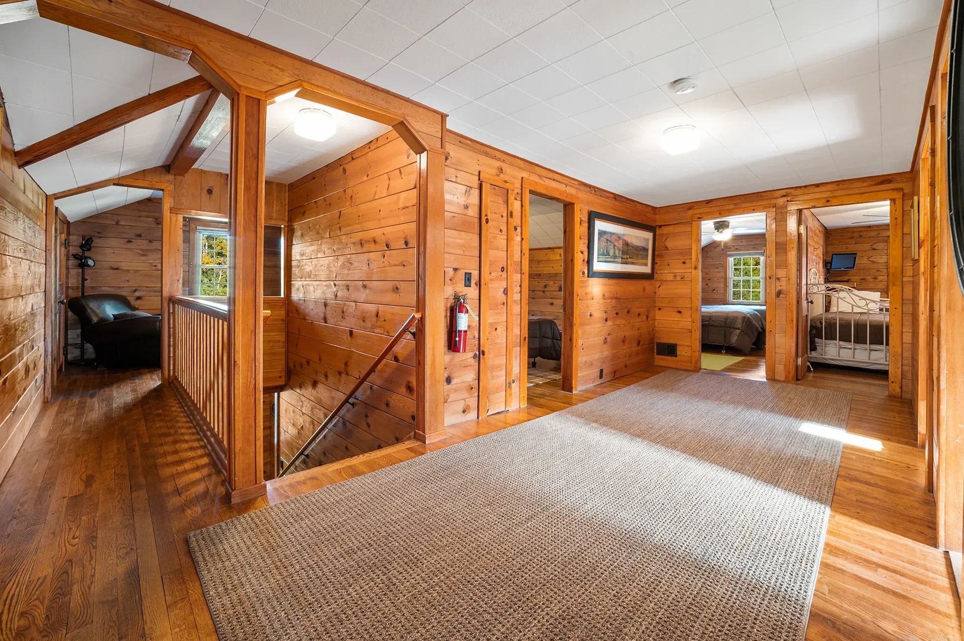 There is a fire extinguisher in the hallway of a log cabin.