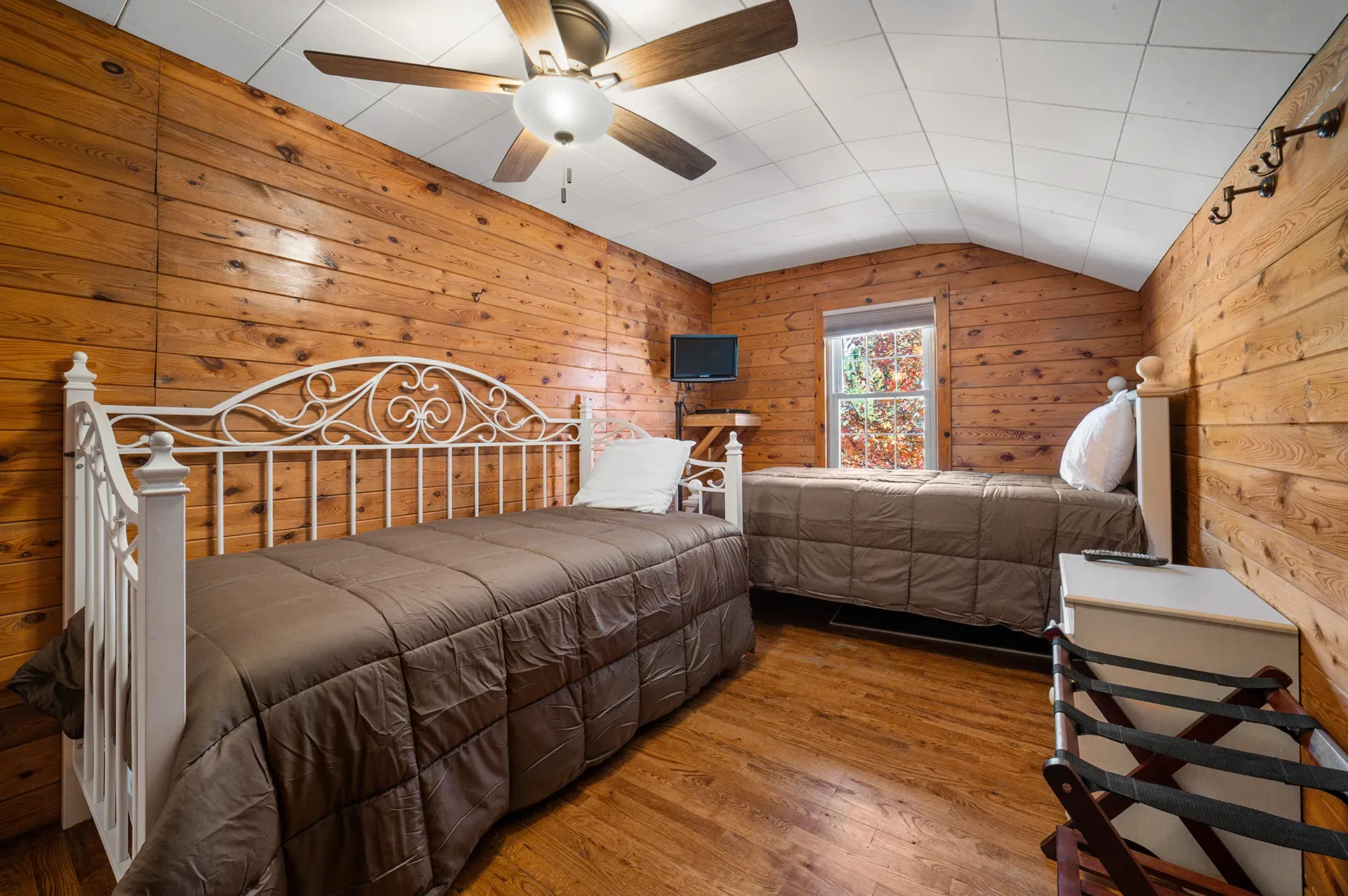 A bedroom with two beds and a ceiling fan.