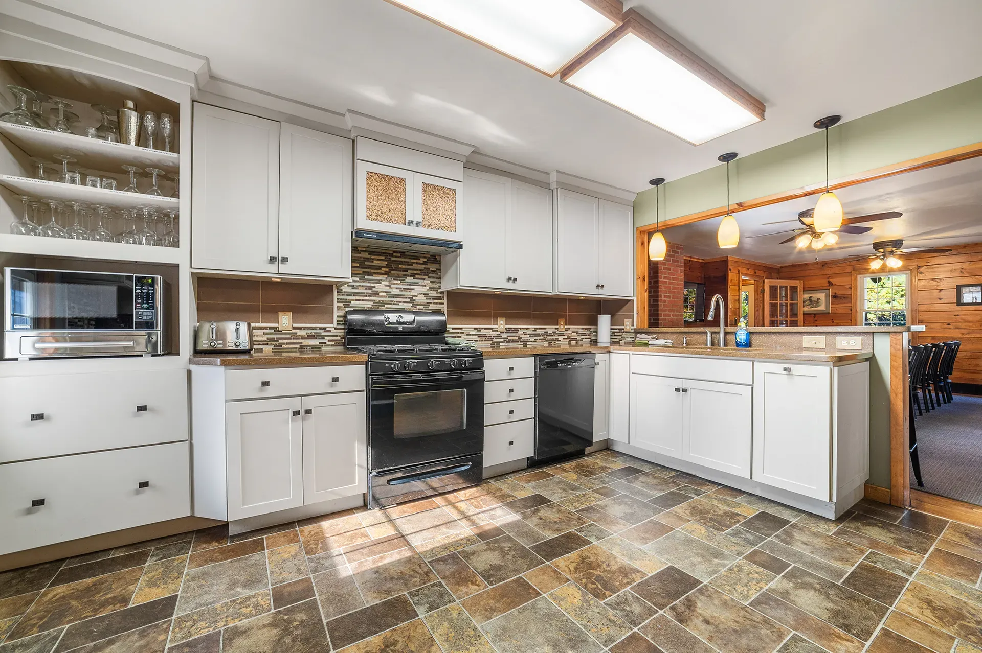 A kitchen with white cabinets and a tile floor