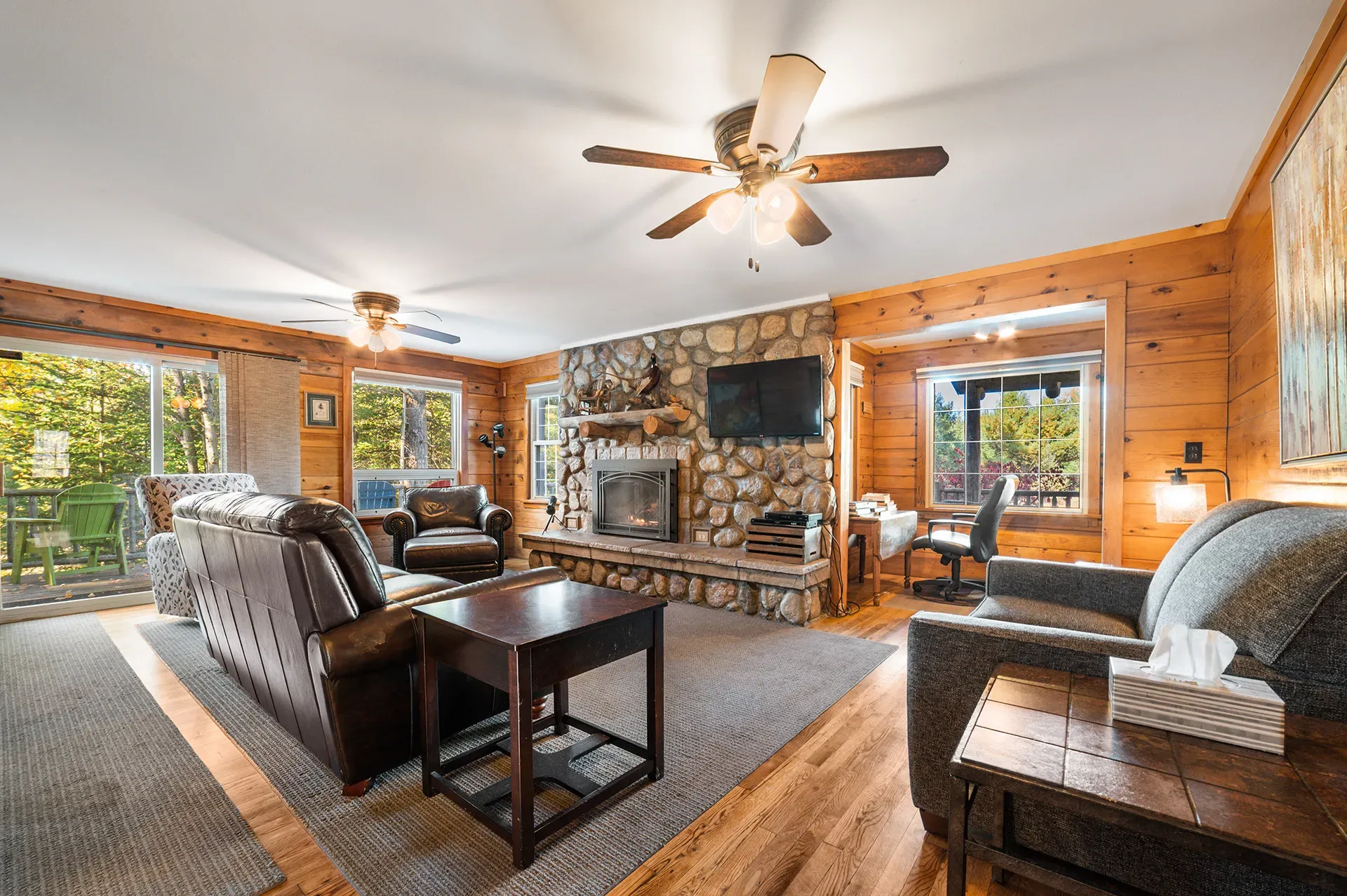 A living room filled with furniture and a fireplace with a ceiling fan.
