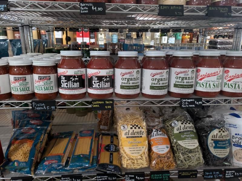 A shelf of pasta and sauces in a store