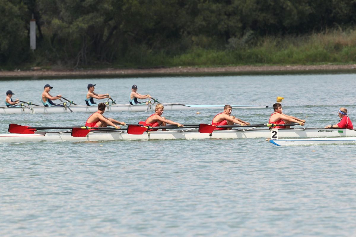 A group of people are rowing boats on a lake.