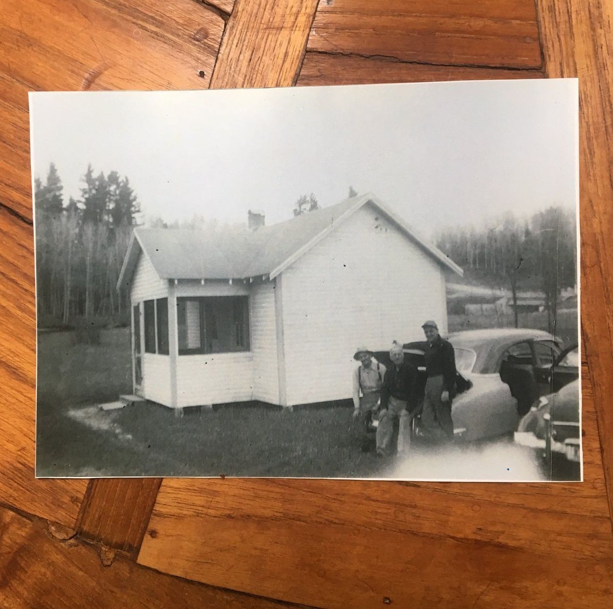 A black and white photo of a small white house