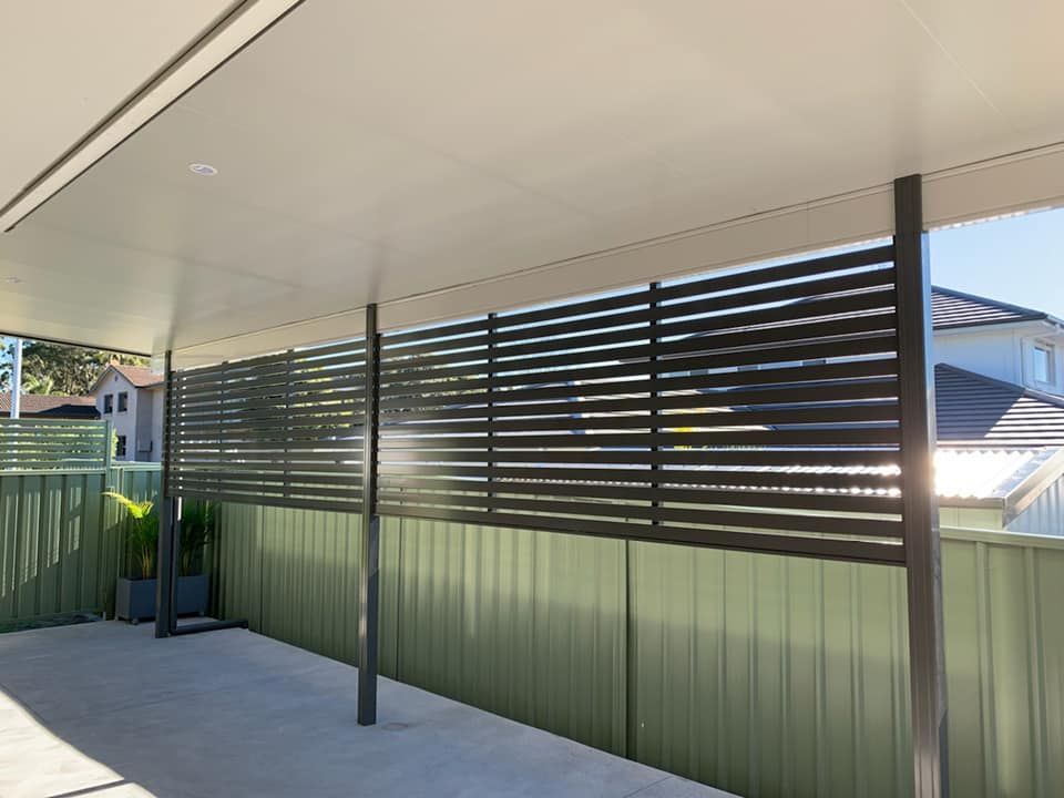A Modern Slatted Fence, Partially Obscuring A Backyard — Ulladulla Blinds & Home Improvements In Ulladulla, NSW