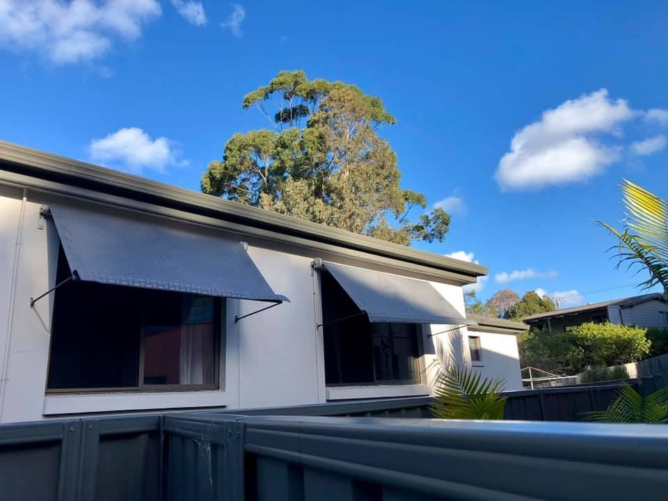 A White House With A Grey Awning On The Windows — Ulladulla Blinds & Home Improvements In Ulladulla, NSW