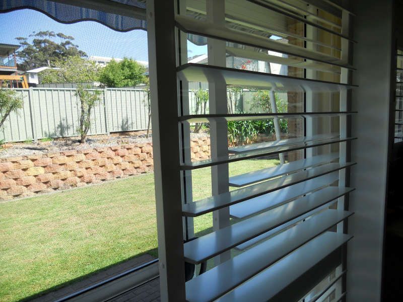 White Plantation Shutters On A Window With A View — Ulladulla Blinds & Home Improvements In Ulladulla, NSW