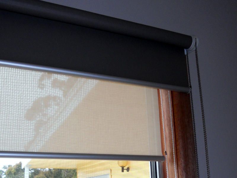 A Beige Roller Blind Partially Rolled Down On A Window — Ulladulla Blinds & Home Improvements In Ulladulla, NSW