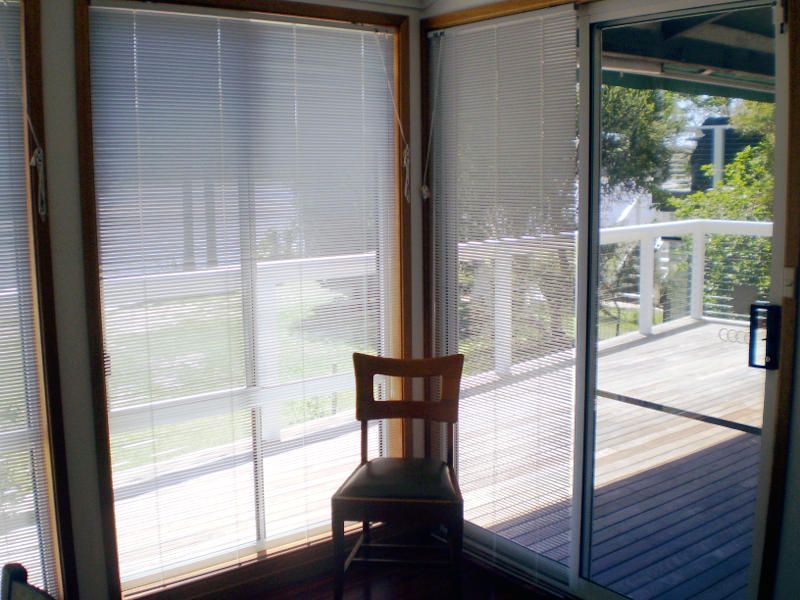 White Timber Venetians On A Sliding Glass Door, Providing Shade And Privacy — Ulladulla Blinds & Home Improvements In Ulladulla, NSW