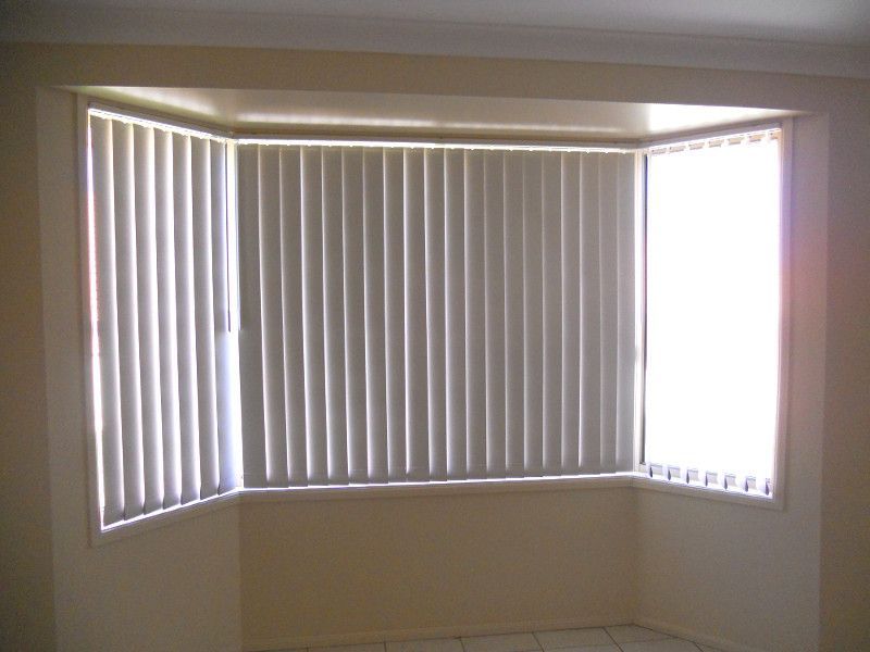 White Vertical Blinds On A Bay Window, Offering Flexibility And Style — Ulladulla Blinds & Home Improvements In Ulladulla, NSW