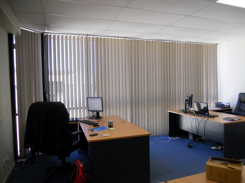 Beige Vertical Blinds In A Home Office, Providing A Professional And Serene Atmosphere — Ulladulla Blinds & Home Improvements In Ulladulla, NSW