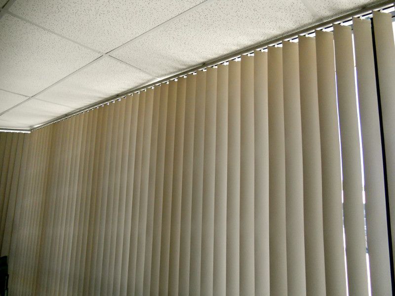 Beige Vertical Blinds In A Corner Window, Offering Flexibility And Style — Ulladulla Blinds & Home Improvements In Ulladulla, NSW