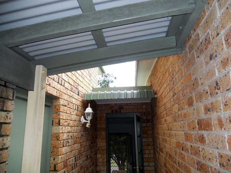 A Covered Walkway Between Two Brick Walls, With A Skylight Visible Above. — Ulladulla Blinds & Home Improvements In Ulladulla, NSW