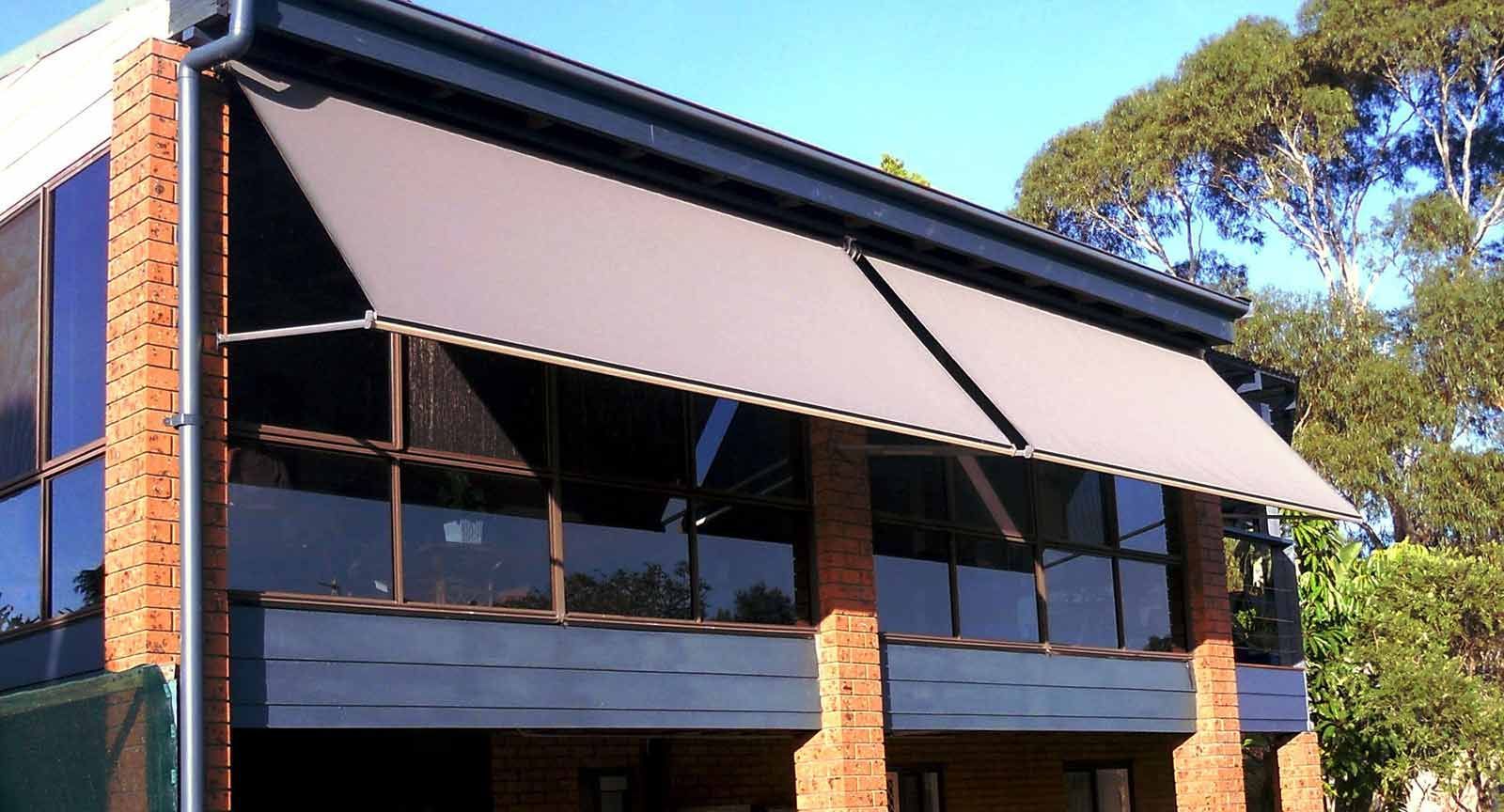 A Brick Building With A Balcony And Awning On It — Ulladulla Blinds & Home Improvements In Ulladulla, NSW