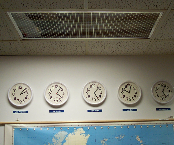 A row of clocks on a wall showing different times around the world