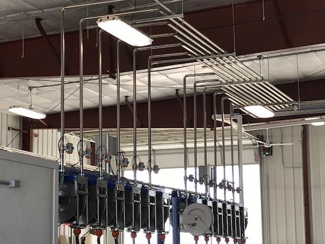 A bunch of pipes are hanging from the ceiling of a building