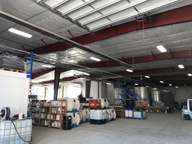 A large warehouse filled with lots of containers and machinery.