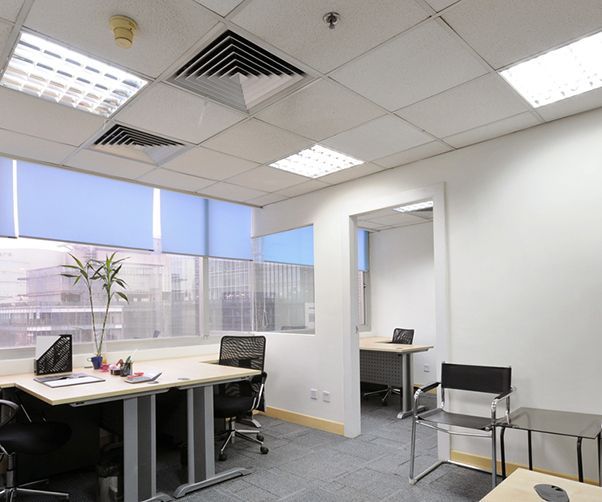 A small office with two desks and two chairs.