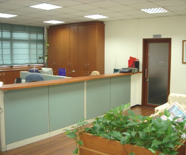 A room with a desk and a plant in it