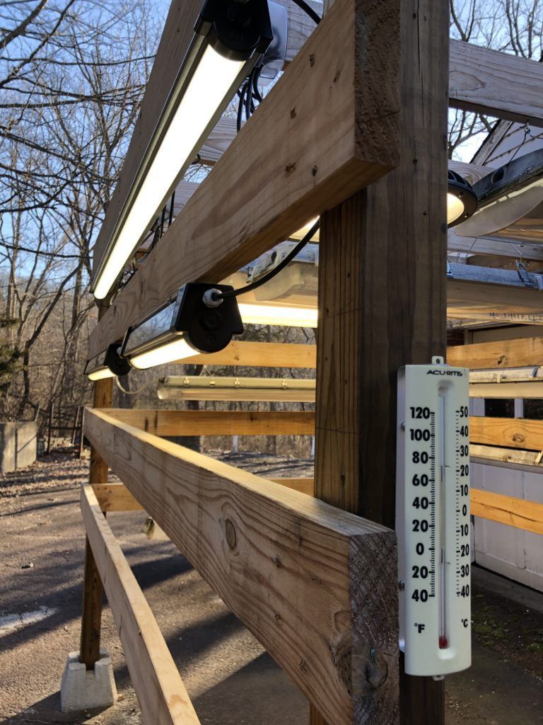 A wooden fence with a thermometer attached to it.