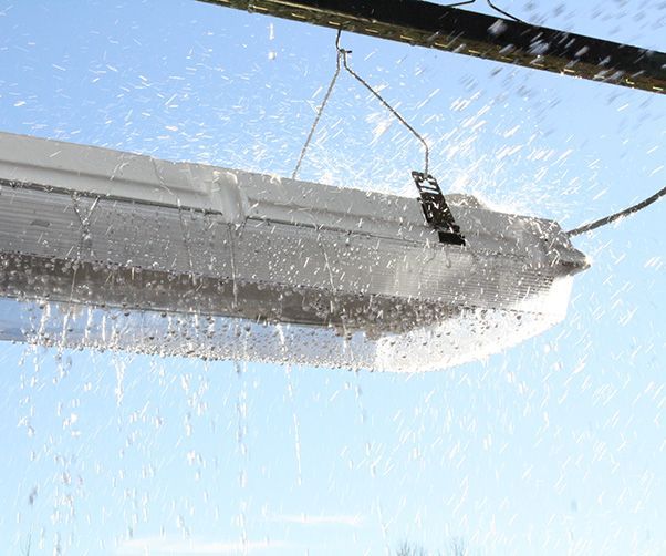A light hanging from a pole with water coming out of it