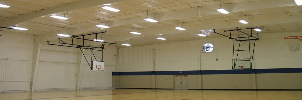A basketball hoop is hanging from the ceiling of a gym.
