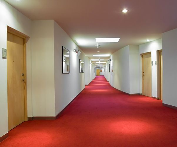 A long hallway with red carpet and white walls