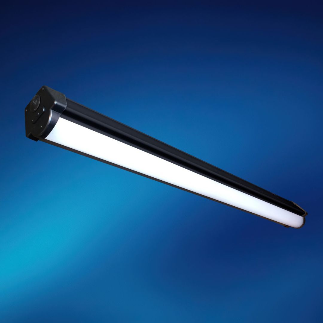 A long black light fixture is against a blue background